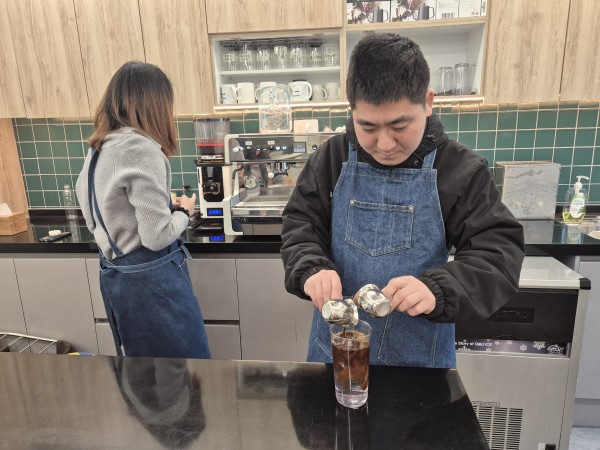 추출된 샷으로 아메리카노를 만드는 모습