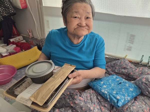 가정에서 생일선물을 받고 포즈를 취하는 이용인의 모습