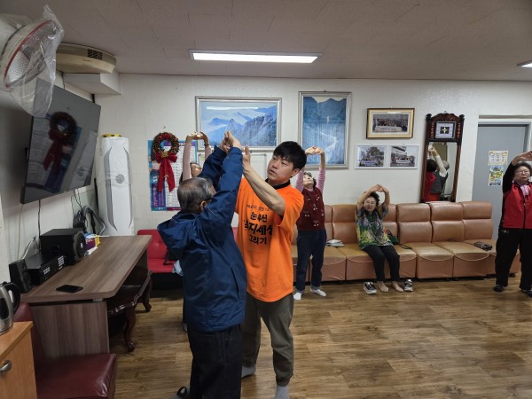 이용인의 자세를 교정해주는 선생님의 모습