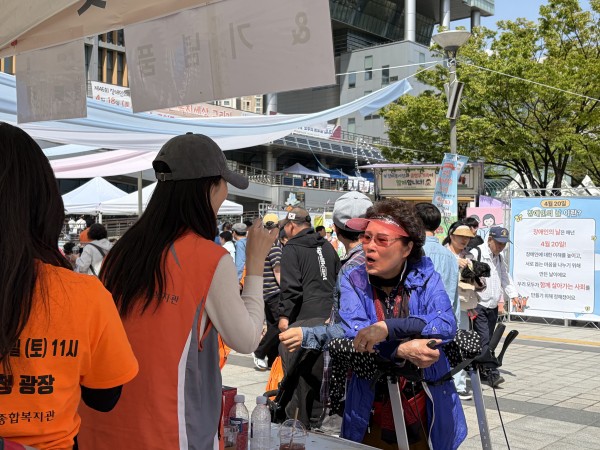 참여자에게 행사 안내하는 봉사자 모습