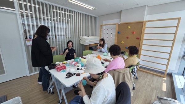 공방에서 뜨개질을 하며 즐겁게 웃고 있는 보호자분들