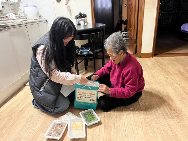 가정 방문하여 반찬 전달하는 모습