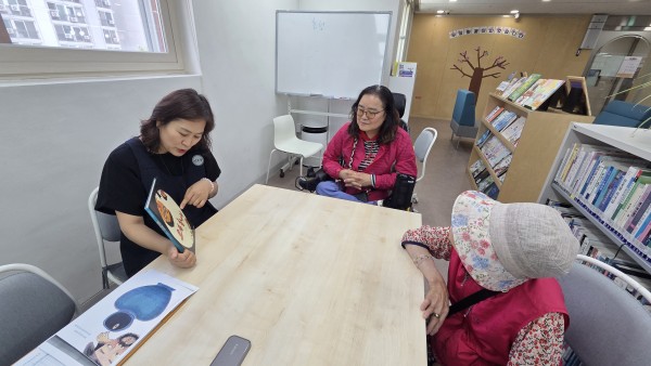 요술항아리 동화책 표지를 보며 이야기하고 있는 모습