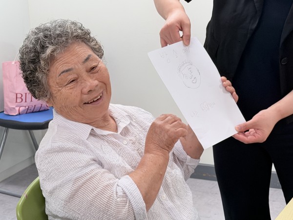보호자분들이 그려준 얼굴 그림을 들고 소개하고 있는 모습