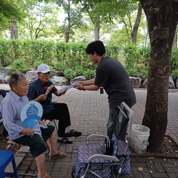 지역주민들에게 내일 행사를 홍보하는 실습생