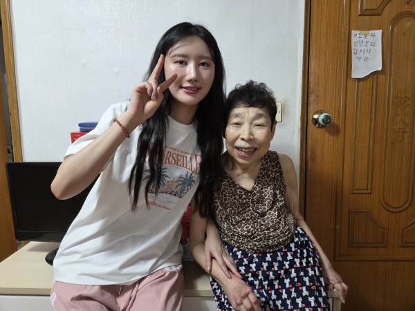 미용봉사자와 함께 사진을 찍는 대상자의 모습