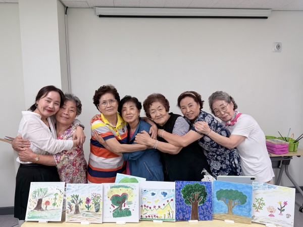 성장의 나무 그림 앞에서 껴안고 사진찍은 모습