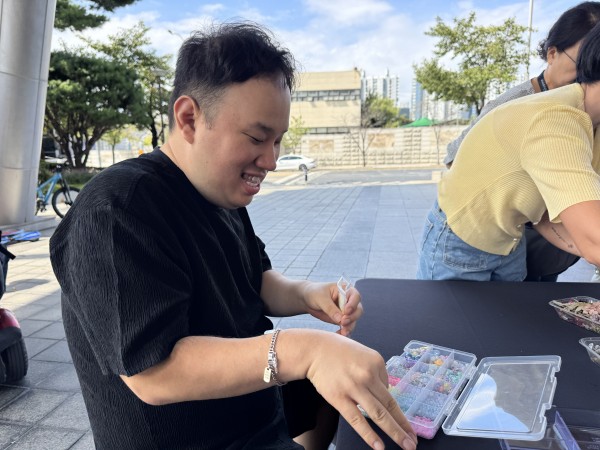 웃으며 비즈를 선택하는 모습
