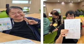 금전관리교육 중 개인별 활동지를 작성하고 같이 사진을 찍고 있는 이용인 모습